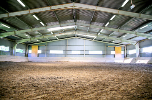 Empty riding hall with sandy covering