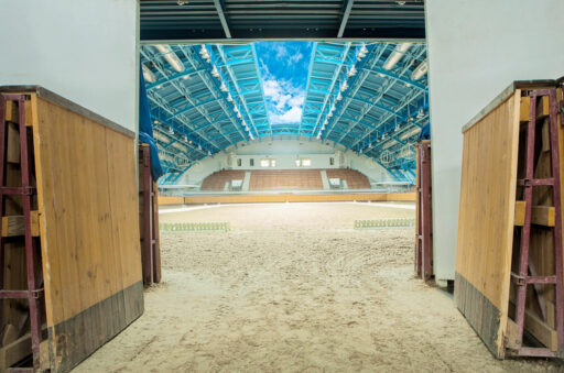Large horse arena interior with open sky